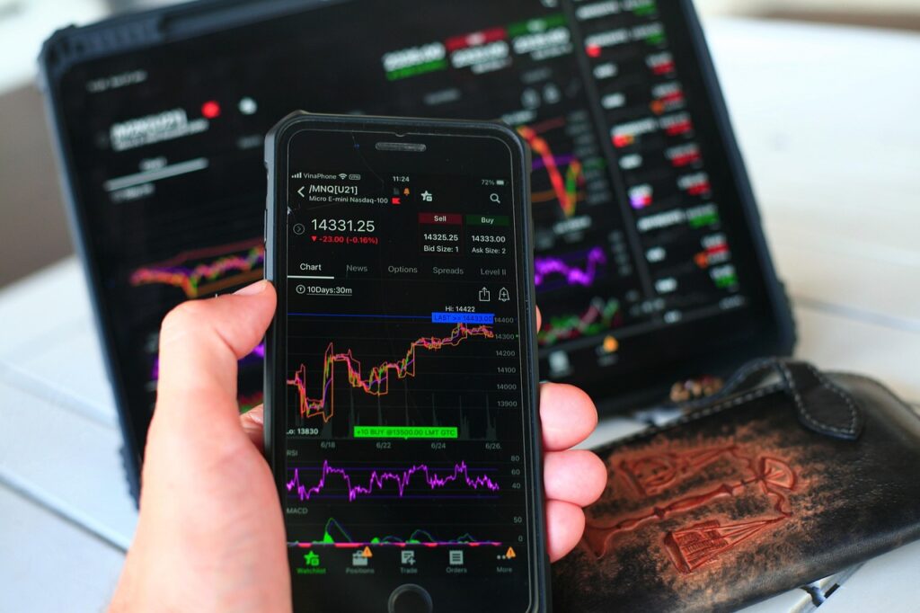 Investidor analisando gráficos de ações brasileiras em aplicativo no celular com cotações em tempo real.